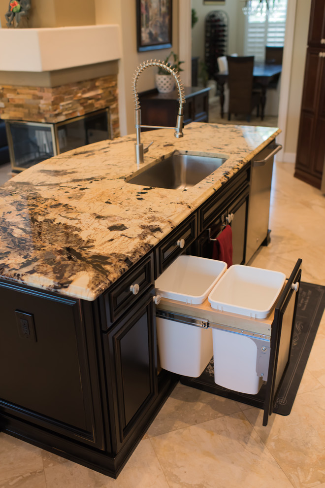 Design ideas for a medium sized classic galley open plan kitchen in Tampa with a submerged sink, raised-panel cabinets, black cabinets, granite worktops, beige splashback, stone slab splashback, stainless steel appliances, travertine flooring and an island.