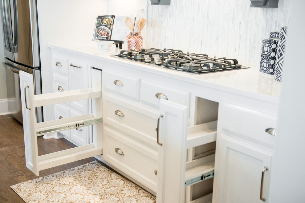 Foto de cocina minimalista con fregadero de doble seno, puertas de armario blancas, electrodomésticos de acero inoxidable y una isla