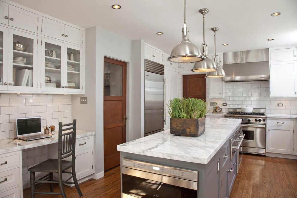 Klassische Küche in grau-weiß mit Küchenrückwand in Weiß, Schrankfronten mit vertiefter Füllung, weißen Schränken, Küchengeräten aus Edelstahl und Marmor-Arbeitsplatte in Los Angeles