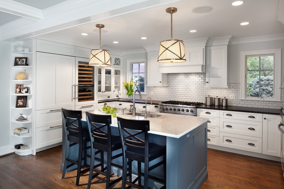 Elegant u-shaped dark wood floor kitchen photo in DC Metro with an undermount sink, shaker cabinets, white cabinets, white backsplash, subway tile backsplash, paneled appliances and an island