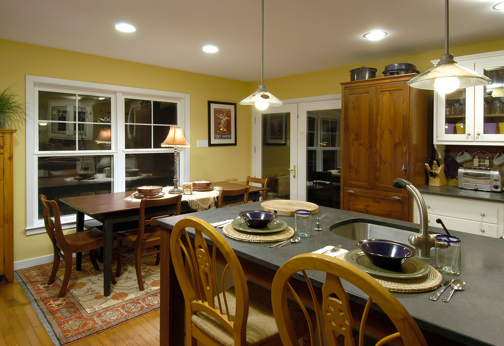 Foto på ett mellanstort amerikanskt kök, med en undermonterad diskho, luckor med glaspanel, vita skåp, bänkskiva i täljsten, beige stänkskydd, stänkskydd i keramik, rostfria vitvaror, mellanmörkt trägolv och beiget golv