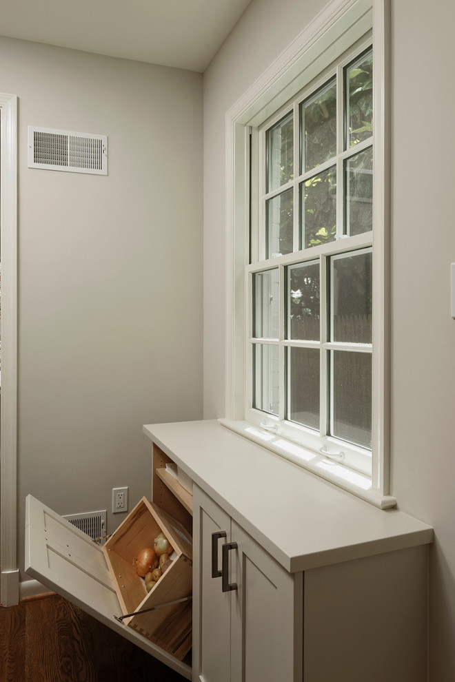 Exempel på ett litet retro kök, med en undermonterad diskho, släta luckor, vita skåp, marmorbänkskiva, beige stänkskydd, integrerade vitvaror, mellanmörkt trägolv, en köksö och stänkskydd i porslinskakel
