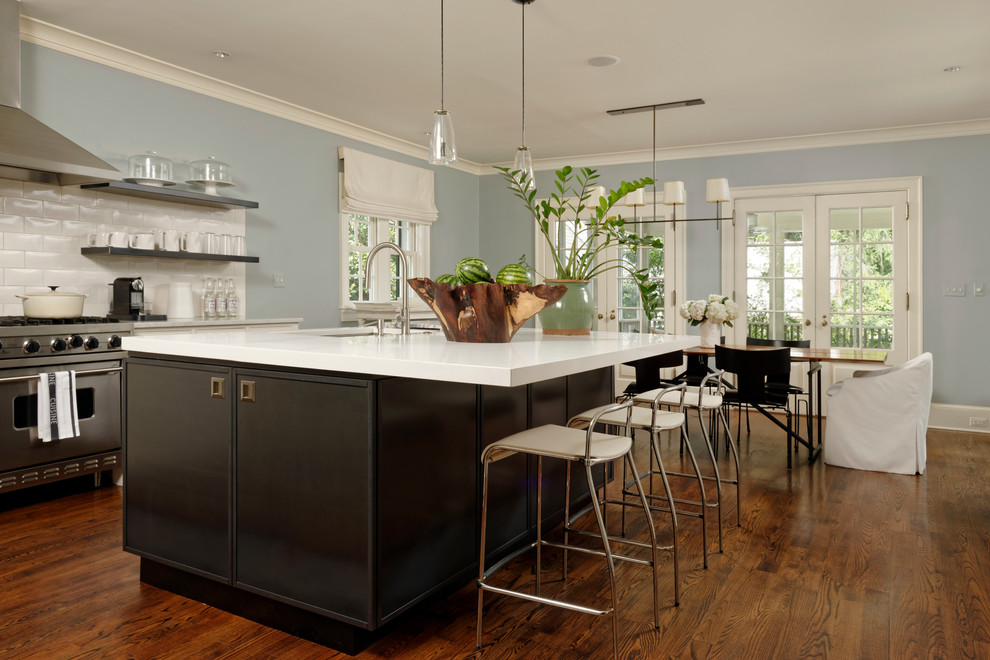 Inspiration for a large transitional l-shaped medium tone wood floor eat-in kitchen remodel in DC Metro with an undermount sink, stainless steel appliances, an island, quartz countertops, white cabinets, white backsplash, ceramic backsplash and recessed-panel cabinets