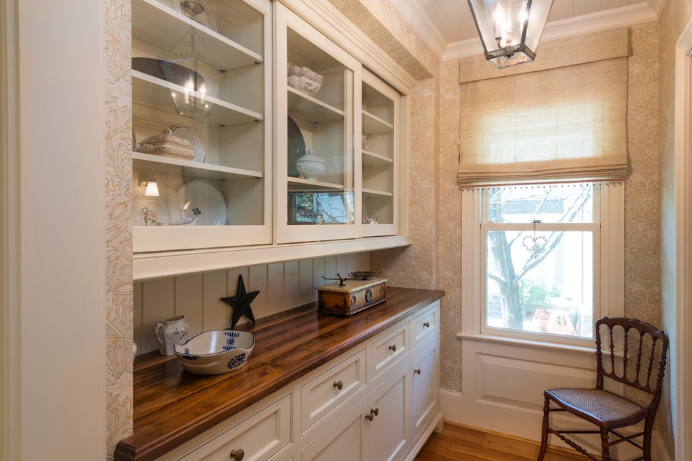 Modelo de cocina clásica de tamaño medio cerrada con armarios con rebordes decorativos, puertas de armario blancas, salpicadero blanco y suelo de madera en tonos medios