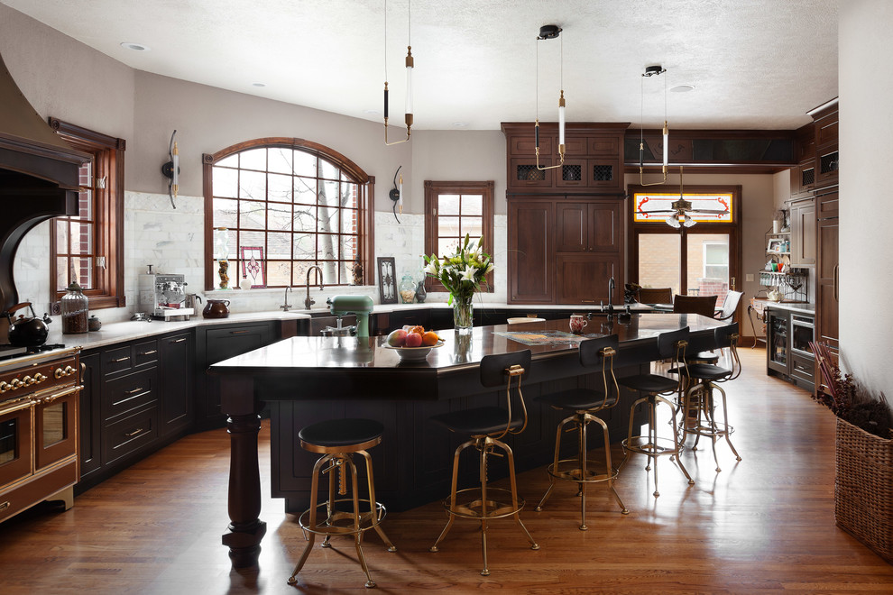 Kitchen - rustic medium tone wood floor and brown floor kitchen idea in Other with a farmhouse sink, shaker cabinets, black cabinets, white backsplash and an island