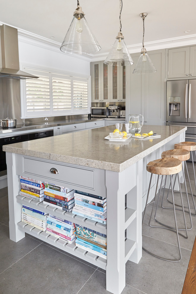 Medium sized traditional l-shaped kitchen/diner in Sydney with a double-bowl sink, shaker cabinets, white cabinets, stainless steel worktops, white splashback, stainless steel appliances, porcelain flooring and an island.