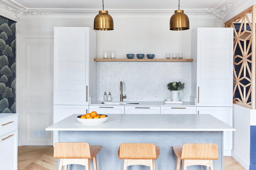 Inspiration for a scandinavian light wood floor kitchen remodel in Paris with an undermount sink, shaker cabinets, white cabinets, gray backsplash, stone slab backsplash, an island and gray countertops