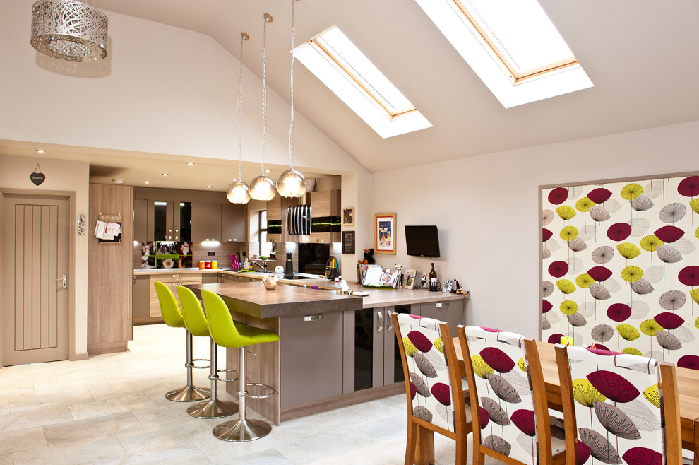 This is an example of a contemporary u-shaped open plan kitchen in Cambridgeshire with porcelain flooring and a breakfast bar.