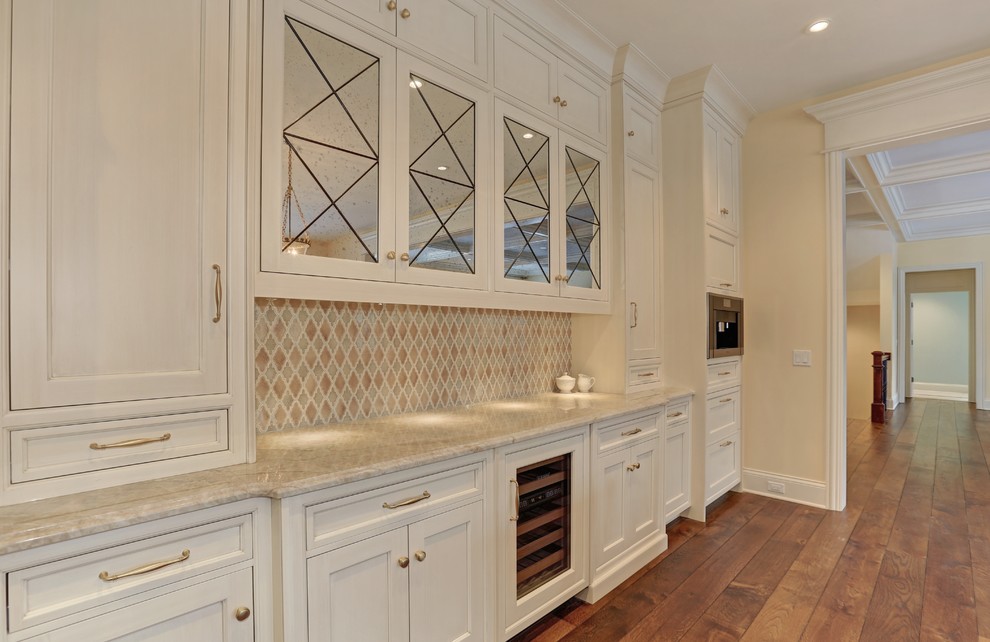 Photo of a large traditional u-shaped open plan kitchen in Chicago with recessed-panel cabinets, white cabinets, granite worktops, multi-coloured splashback, ceramic splashback, white appliances and medium hardwood flooring.