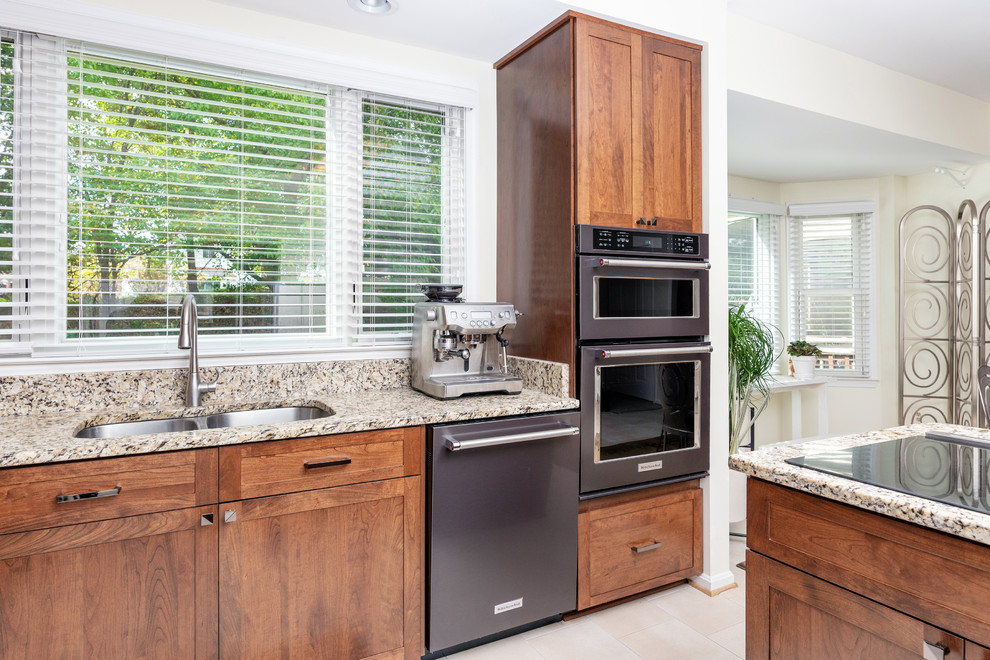 Foto di una cucina design di medie dimensioni con lavello sottopiano, ante in stile shaker, top in granito, elettrodomestici neri e top beige
