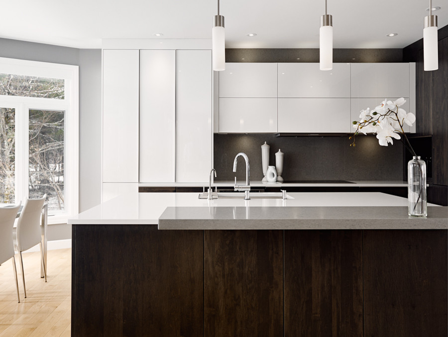 Photo of a large modern l-shaped kitchen/diner in Other with a submerged sink, flat-panel cabinets, white cabinets, engineered stone countertops, stone slab splashback, stainless steel appliances, light hardwood flooring and an island.