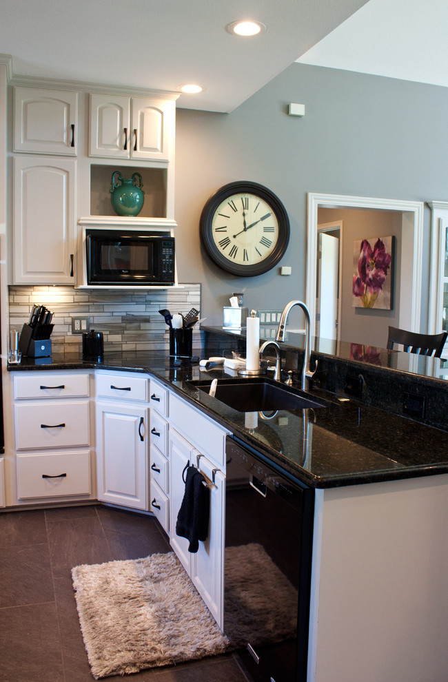 Klassische Küche mit weißen Schränken, Küchenrückwand in Grau, Rückwand aus Mosaikfliesen, Granit-Arbeitsplatte, schwarzen Elektrogeräten und Porzellan-Bodenfliesen in Wichita