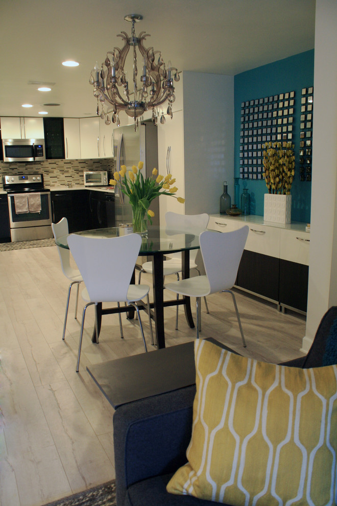 Foto di una piccola sala da pranzo aperta verso il soggiorno moderna con pareti blu e pavimento in laminato