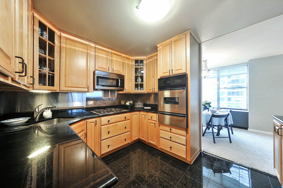 Foto på ett litet funkis kök, med en undermonterad diskho, luckor med upphöjd panel, skåp i ljust trä, granitbänkskiva, stänkskydd med metallisk yta, stänkskydd i cementkakel, rostfria vitvaror och marmorgolv
