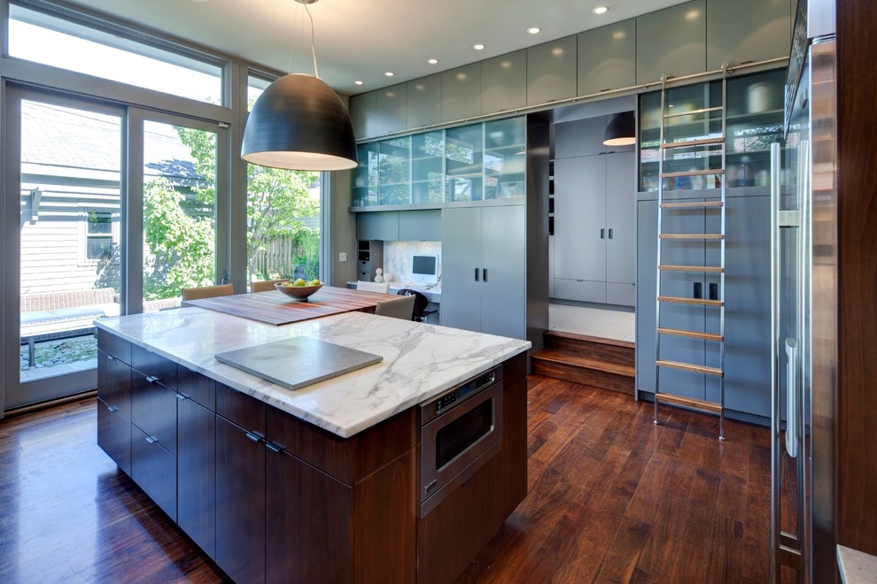 Trendy enclosed kitchen photo in Chicago with flat-panel cabinets, gray cabinets and stone slab backsplash