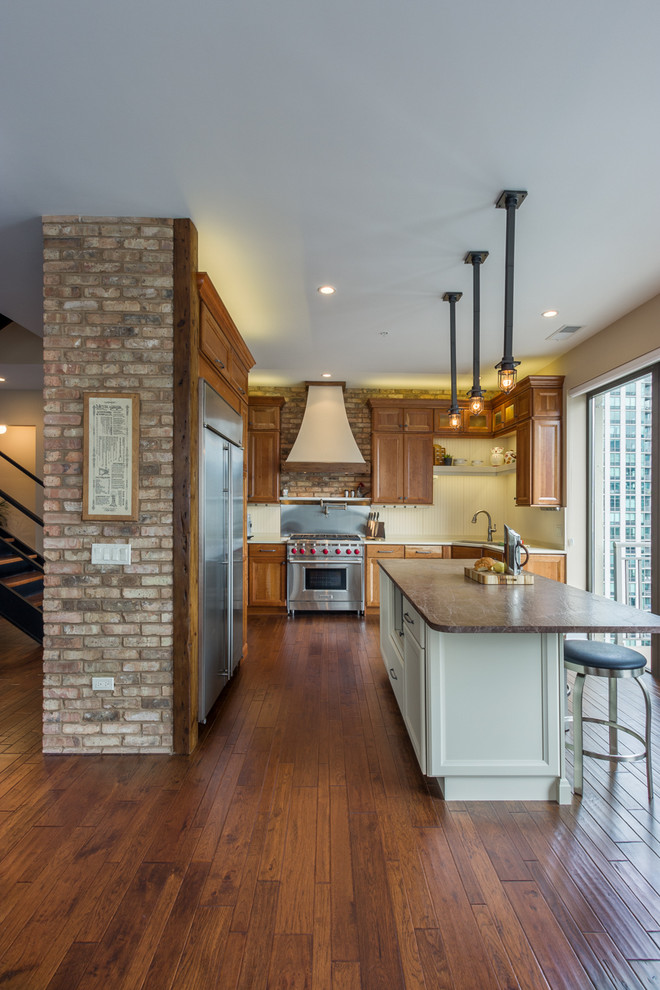 Inspiration for a mid-sized timeless l-shaped dark wood floor open concept kitchen remodel in Chicago with recessed-panel cabinets, medium tone wood cabinets, white backsplash, stainless steel appliances and an island