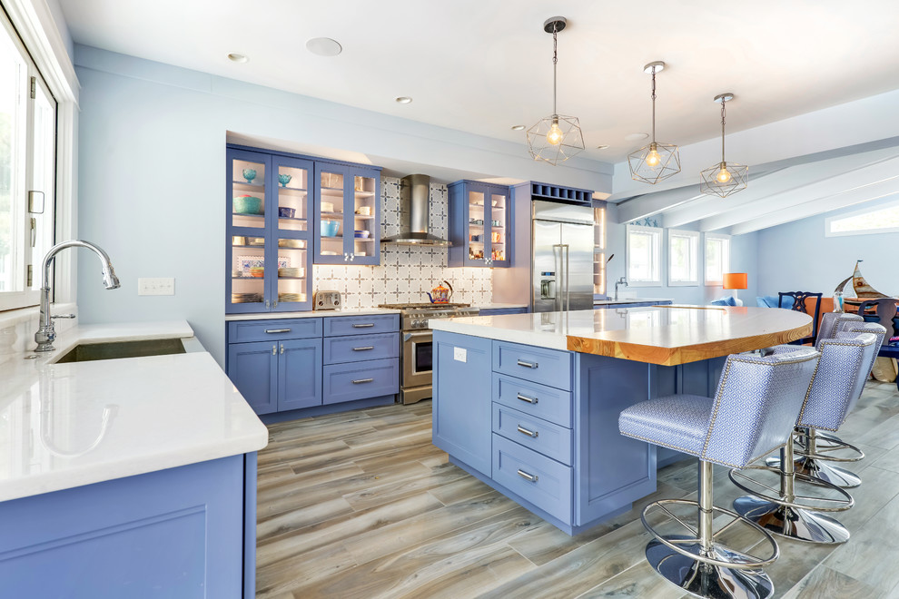 Bild på ett stort eklektiskt vit vitt kök, med en rustik diskho, luckor med upphöjd panel, blå skåp, marmorbänkskiva, flerfärgad stänkskydd, stänkskydd i cementkakel, rostfria vitvaror, klinkergolv i porslin, en köksö och grått golv