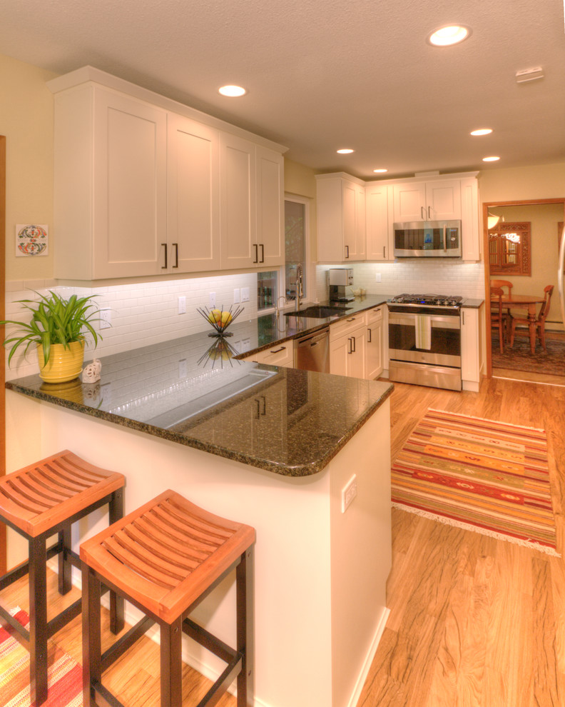 Foto di una cucina ad U classica con ante bianche, top in granito, paraspruzzi con piastrelle di cemento e elettrodomestici colorati