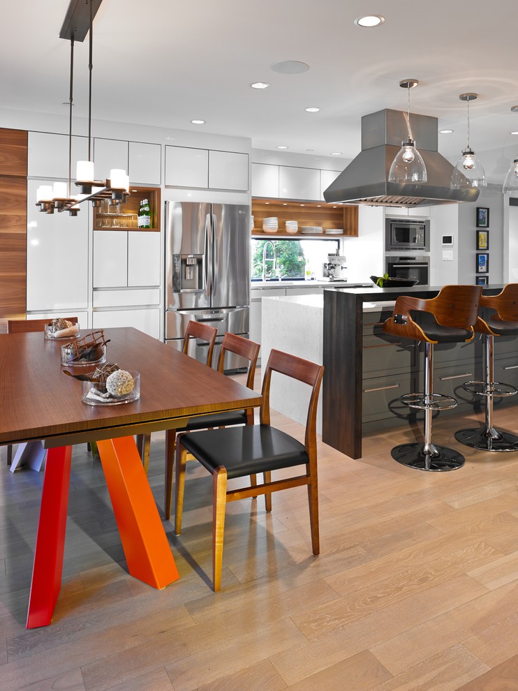 Стильный дизайн: параллельная кухня в современном стиле с обеденным столом, плоскими фасадами, белыми фасадами и техникой из нержавеющей стали - последний тренд