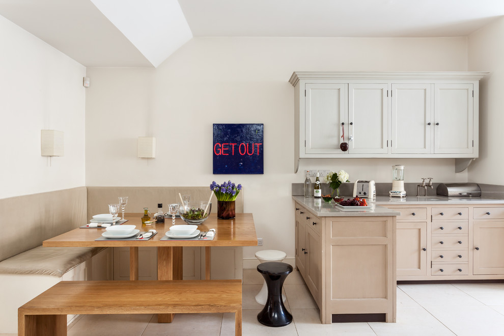 Klassische Wohnküche mit Schrankfronten im Shaker-Stil, beigen Schränken, Kalkstein, Halbinsel, Quarzit-Arbeitsplatte und weißem Boden in London