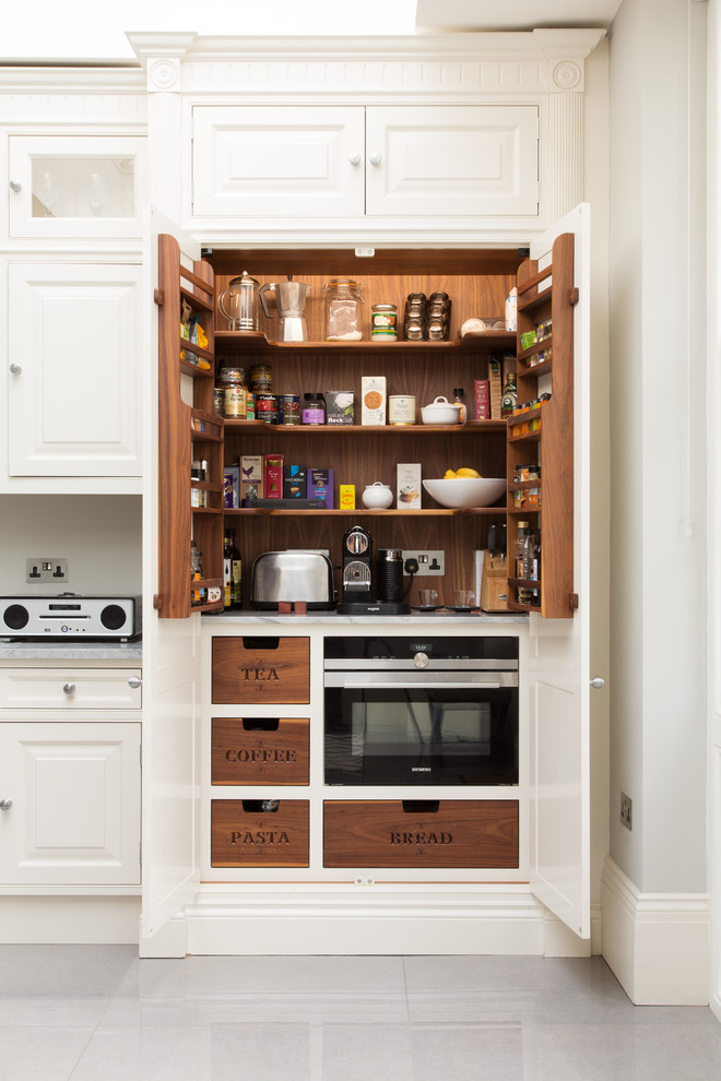 Kitchen pantry - traditional kitchen pantry idea in London with raised-panel cabinets and white cabinets