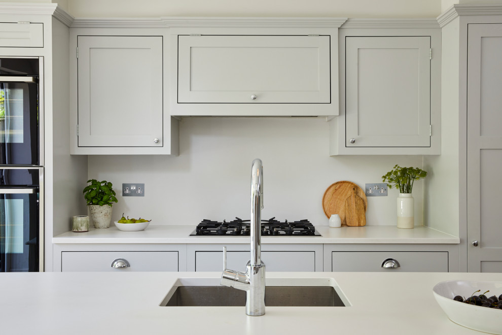 Exempel på ett stort modernt vit linjärt vitt kök och matrum, med en nedsänkt diskho, skåp i shakerstil, grå skåp, bänkskiva i koppar, vitt stänkskydd, mellanmörkt trägolv, en köksö och brunt golv