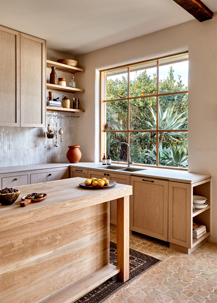 Inspiration for a large mediterranean l-shaped kitchen in Melbourne with a submerged sink, shaker cabinets, light wood cabinets, an island, beige floors and grey worktops.
