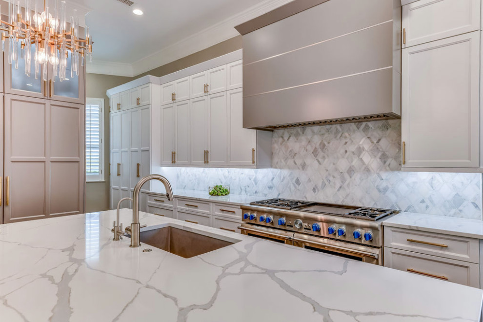 Exempel på ett stort klassiskt vit vitt kök, med en undermonterad diskho, skåp i shakerstil, bänkskiva i kvarts, vitt stänkskydd, stänkskydd i marmor, integrerade vitvaror, mellanmörkt trägolv, en köksö, brunt golv och vita skåp