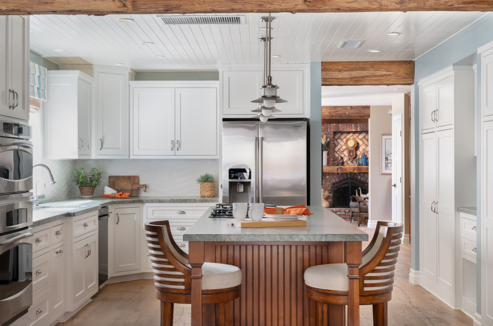 Enclosed kitchen - mid-sized transitional u-shaped brown floor, medium tone wood floor and shiplap ceiling enclosed kitchen idea in Orange County with white cabinets, granite countertops, white backsplash, stainless steel appliances, an island, gray countertops, shaker cabinets and porcelain backsplash
