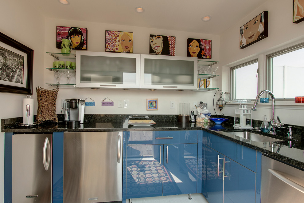 Cette image montre une cuisine design de taille moyenne avec un évier encastré, un placard à porte plane, des portes de placard bleues, un électroménager en acier inoxydable et aucun îlot.