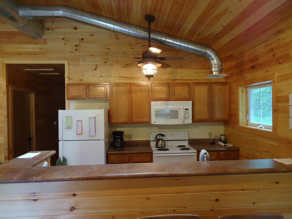 Exemple d'une petite cuisine ouverte montagne en U et bois clair avec un évier posé, un placard à porte shaker, un plan de travail en stratifié, une crédence blanche, un électroménager blanc et une péninsule.
