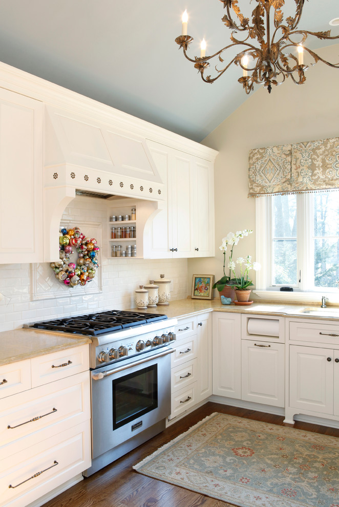 Elegant kitchen photo in Philadelphia with raised-panel cabinets, white backsplash, subway tile backsplash and stainless steel appliances