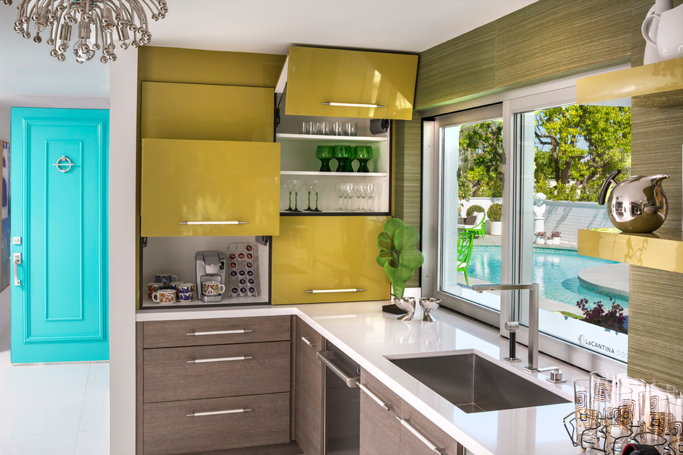 Retro Küche in L-Form mit Unterbauwaschbecken, flächenbündigen Schrankfronten, gelben Schränken und Küchengeräten aus Edelstahl in Los Angeles
