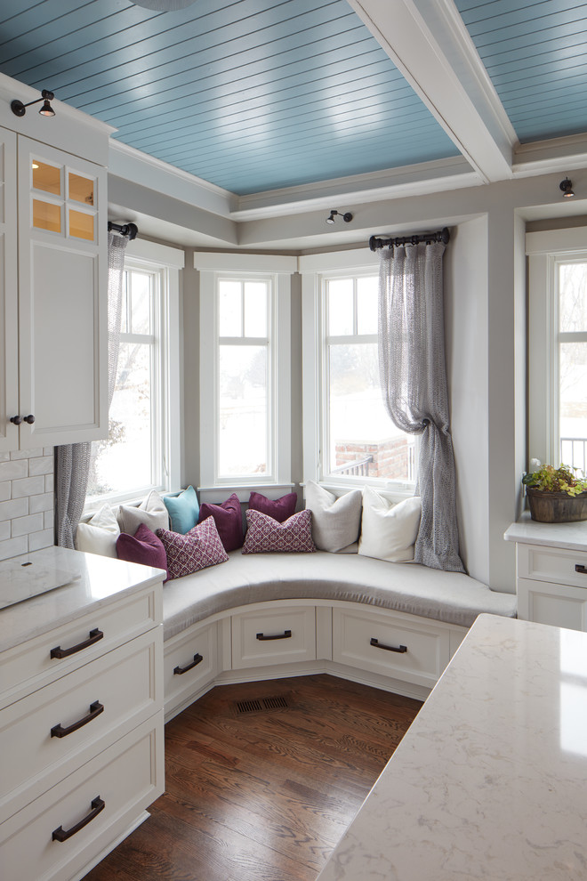 Large elegant u-shaped dark wood floor and brown floor eat-in kitchen photo in Omaha with shaker cabinets, white cabinets, quartz countertops, blue backsplash, wood backsplash, colored appliances and an island