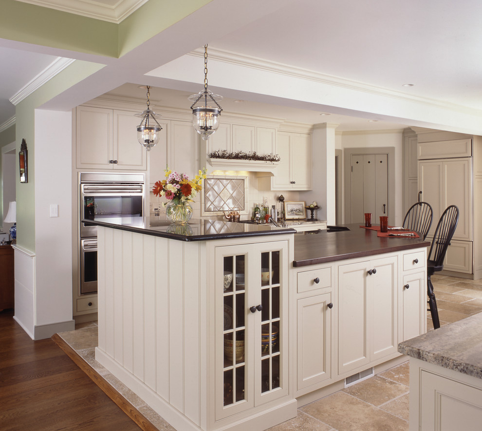 Open concept kitchen - large traditional u-shaped open concept kitchen idea in New York with raised-panel cabinets, white cabinets and two islands