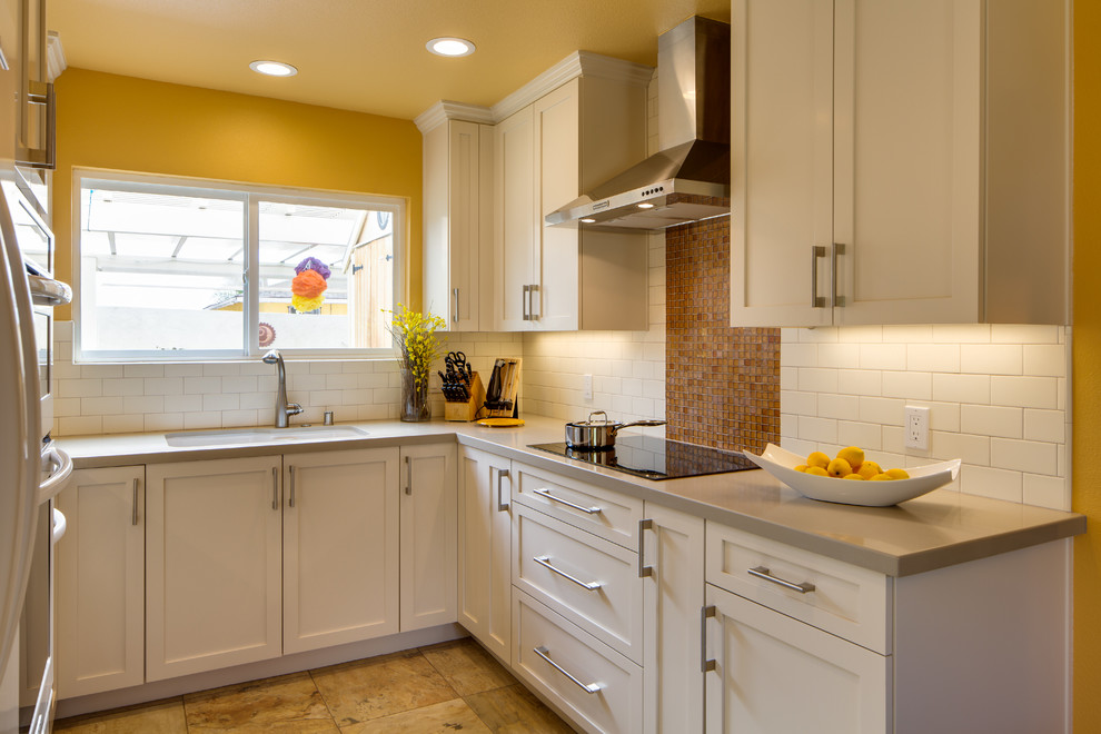 Example of a small classic u-shaped ceramic tile eat-in kitchen design in San Diego with an undermount sink, shaker cabinets, white cabinets, quartz countertops, white backsplash, subway tile backsplash, white appliances and no island