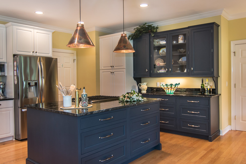 Large transitional u-shaped light wood floor open concept kitchen photo in Charleston with an undermount sink, recessed-panel cabinets, blue cabinets, granite countertops, black backsplash, stone slab backsplash, stainless steel appliances and an island