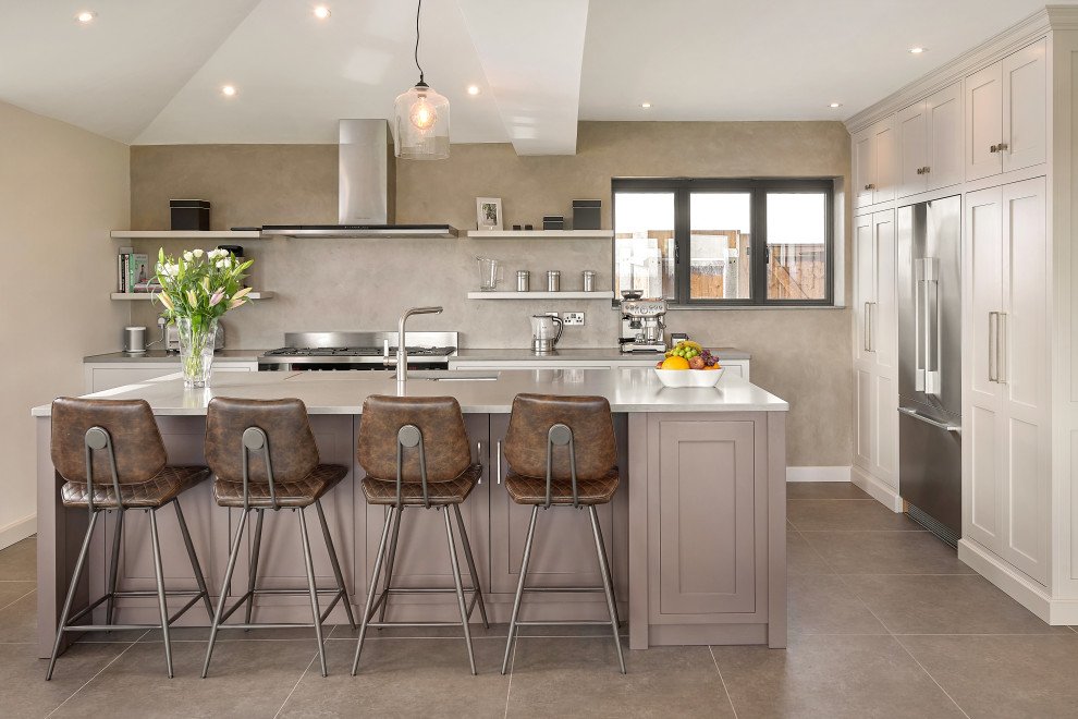 Inspiration for a classic u-shaped kitchen in West Midlands with a submerged sink, shaker cabinets, white cabinets, engineered stone countertops, beige splashback, stainless steel appliances, an island, beige floors and beige worktops.