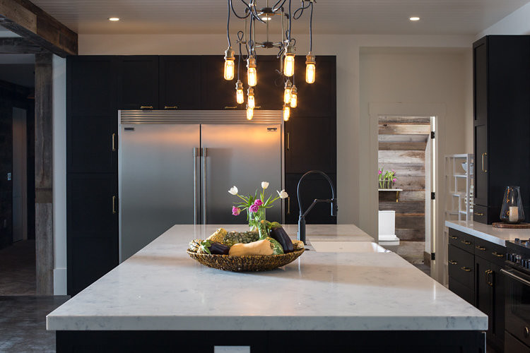 Example of a large urban single-wall concrete floor eat-in kitchen design in San Francisco with a double-bowl sink, shaker cabinets, black cabinets, solid surface countertops, beige backsplash, stainless steel appliances and an island