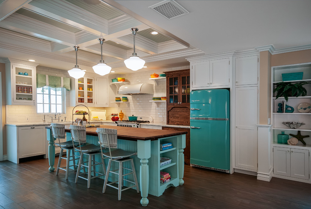 Example of a mid-sized beach style l-shaped kitchen design in San Diego with a farmhouse sink, white backsplash, subway tile backsplash, colored appliances and an island