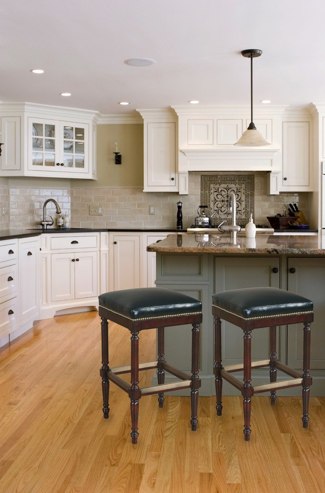 Example of a classic l-shaped kitchen design in Houston with white cabinets