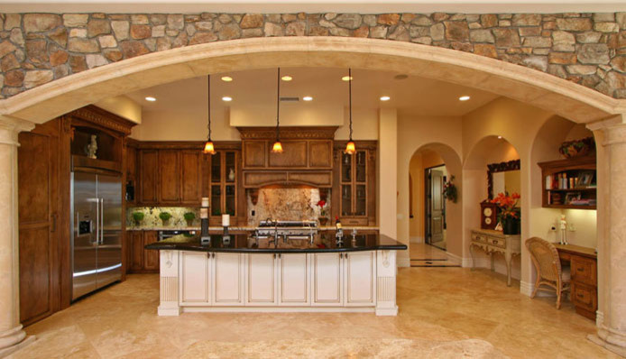 Inspiration for a large mediterranean l-shaped enclosed kitchen remodel in San Diego with a triple-bowl sink, raised-panel cabinets, medium tone wood cabinets, granite countertops, multicolored backsplash, stone slab backsplash, stainless steel appliances and an island