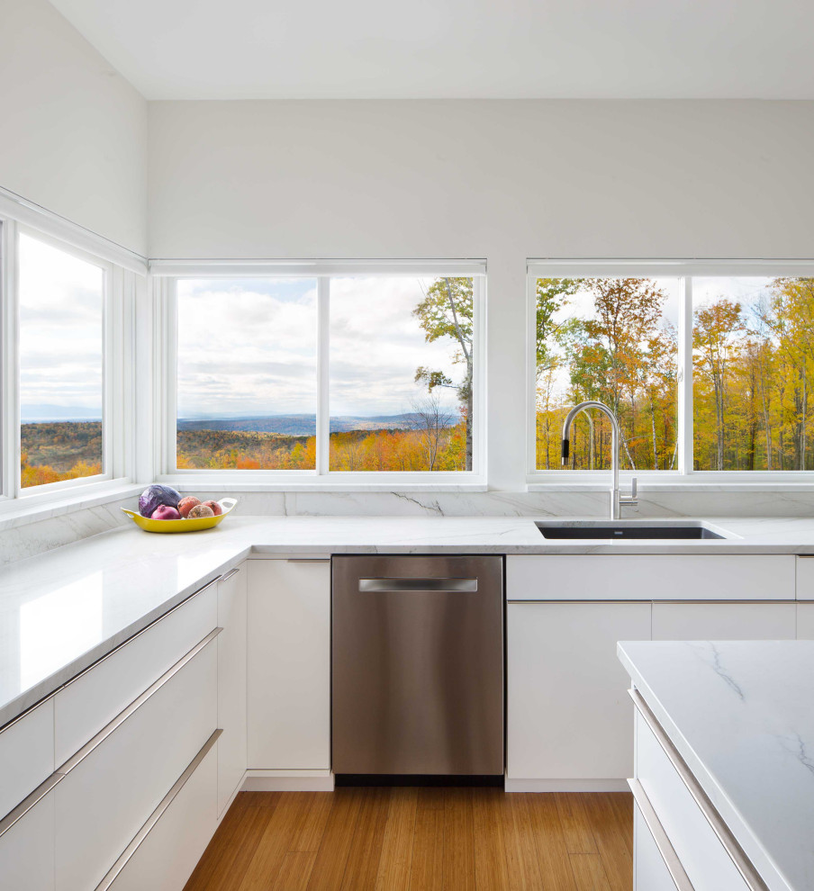 Contemporary kitchen in Burlington with flat-panel cabinets, white cabinets, quartz worktops, white splashback, an island and white worktops.