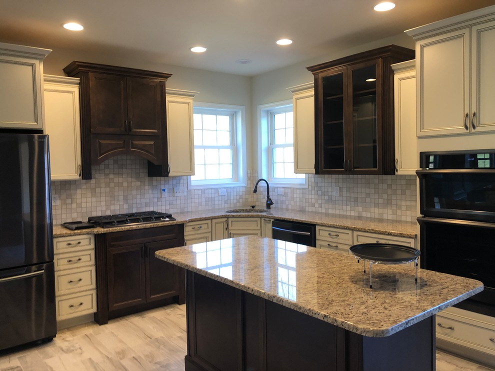Photo of a large traditional l-shaped kitchen/diner in Baltimore with a submerged sink, flat-panel cabinets, beige cabinets, granite worktops, black appliances, an island and beige worktops.