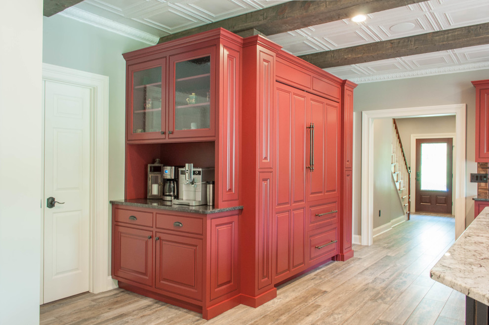 Ejemplo de cocina clásica grande con armarios con rebordes decorativos, puertas de armario rojas, electrodomésticos de acero inoxidable y una isla