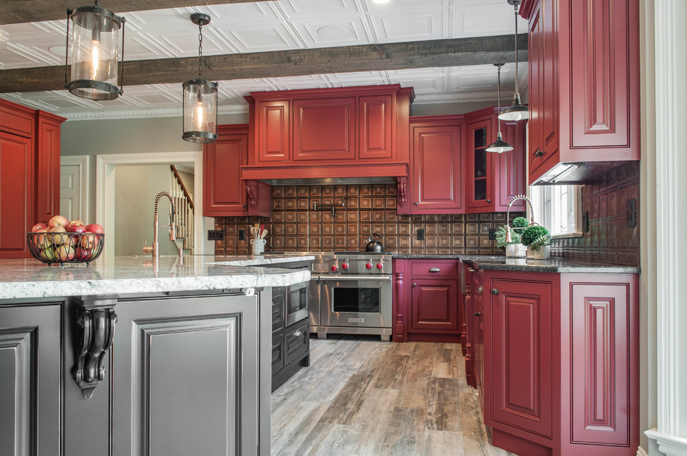 他の地域にある広いトラディショナルスタイルのおしゃれなアイランドキッチン (インセット扉のキャビネット、赤いキャビネット、シルバーの調理設備) の写真