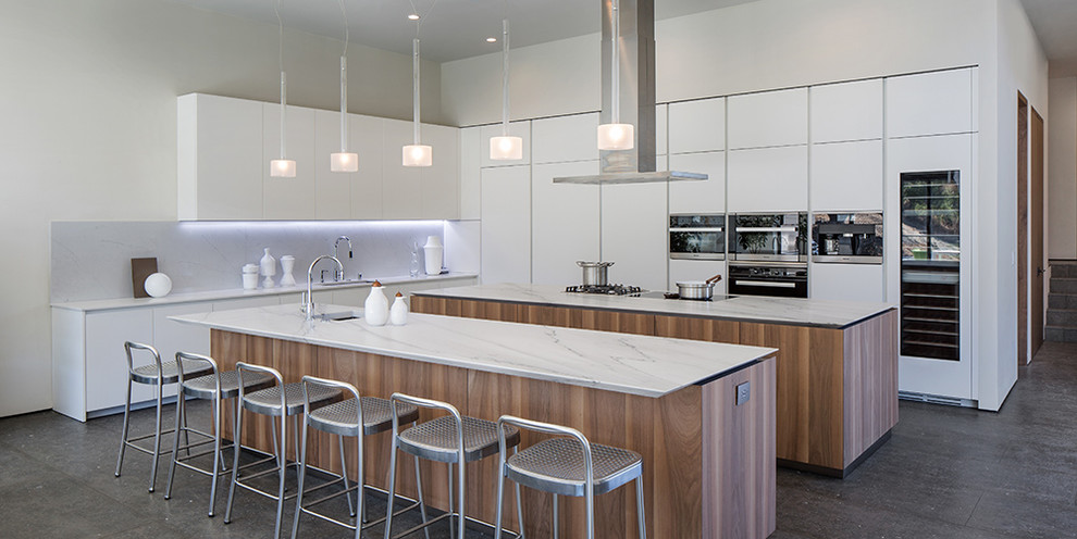 Inspiration for a large contemporary l-shaped kitchen/diner in San Francisco with a built-in sink, white cabinets, stainless steel appliances and multiple islands.