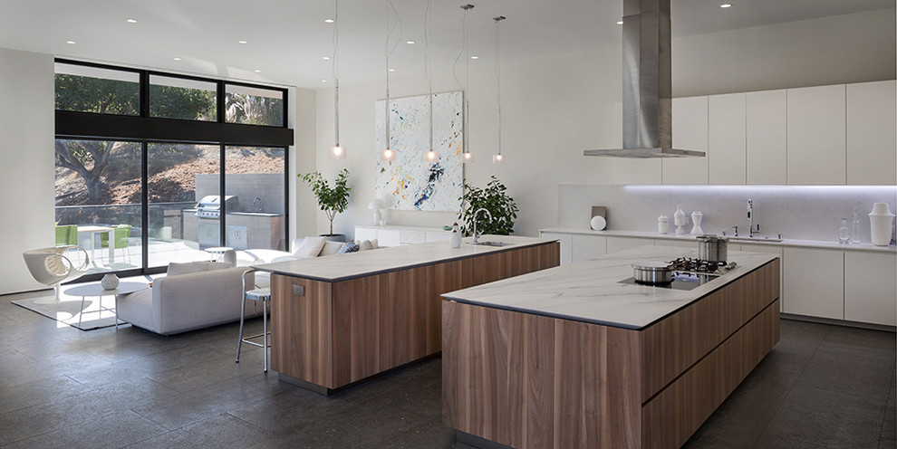 Photo of a large contemporary l-shaped kitchen/diner in San Francisco with a built-in sink, white cabinets, stainless steel appliances and multiple islands.