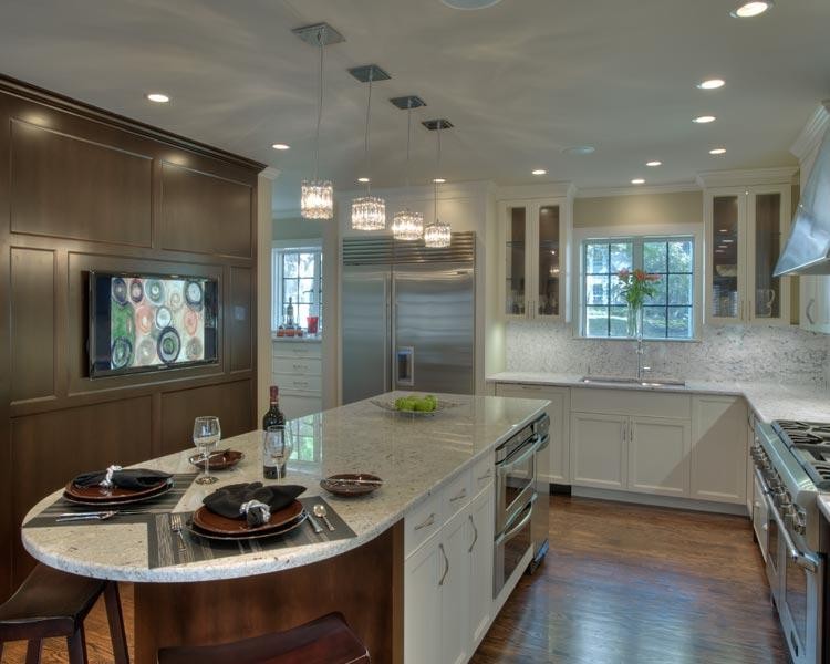 Mid-sized trendy l-shaped light wood floor enclosed kitchen photo in Kansas City with a double-bowl sink, beaded inset cabinets, white cabinets, granite countertops, white backsplash, stone slab backsplash, stainless steel appliances and an island