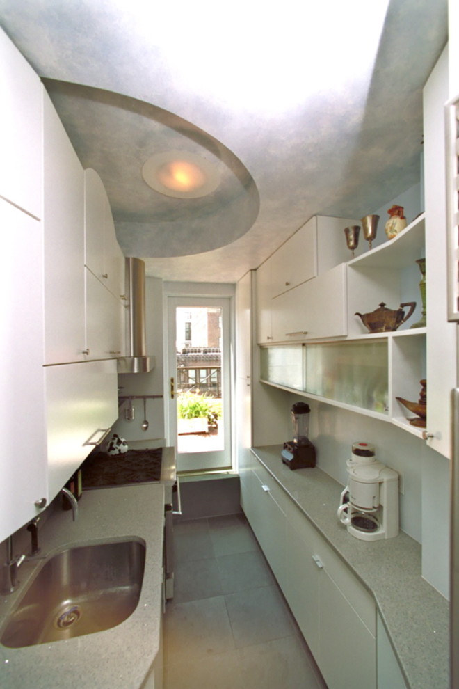 Example of a small minimalist galley slate floor eat-in kitchen design in New York with an undermount sink, flat-panel cabinets, white cabinets, quartz countertops, blue backsplash, stainless steel appliances and no island
